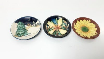 Lot 1235 - Three Moorcroft pottery pin dishes including Christmas Eve, by Sian Leeper, Panache, dated 2004, and Inca Sunflower, dated 94, all 12cm diameter, all boxed