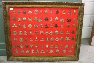 Lot 738 - Large glazed frame mounted with approximately 84 British military cap badges (originals and reproductions noted), 86 x 67cm overall.