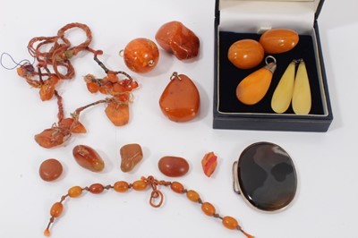 Lot 309 - Group of loose amber beads, two amber pendants, pair clip on earrings, oval agate panel etc