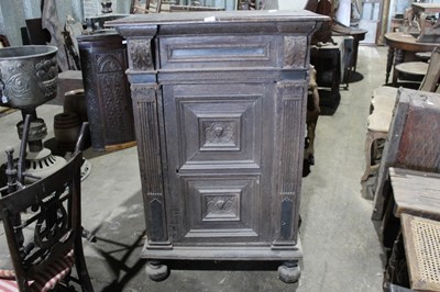 Lot 120 - Late 17th / early 18th century Flemish oak and ebony standing cupboard, with projecting canopy raised on carved corbels and enclosed by single carved panel door between fluted columns, on bun feet,...