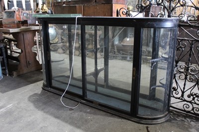 Lot 151 - Victorian ebonised shop display cabinet with bowed glazed ends  and two glazed sliding doors enclosing glass shelves 156 cm long, 84 cm high, 24.5 cm deep