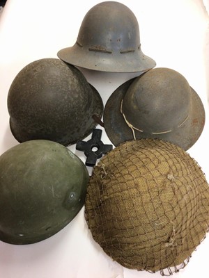 Lot 798 - Second World War British Military steel helmet with canvas webbing and netting covering, another steel helmet dated 1941, a MKIII steel helmet and two others (5)