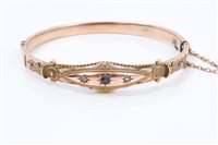 Lot 713 - Rose gold (9ct) hinged bangle with a sapphire...