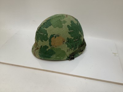Lot 765 - American Vietnam era M1 steel helmet, complete with camo cover, liner and chinstrap, the cover with graffiti 'Khe Sanh 68, Semper FI, Charlie 13 kills'.