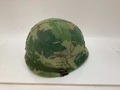 Lot 765 - American Vietnam era M1 steel helmet, complete with camo cover, liner and chinstrap, the cover with graffiti 'Khe Sanh 68, Semper FI, Charlie 13 kills'.