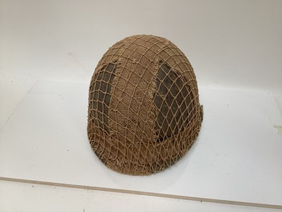 Lot 776 - American M1 steel helmet manufactured circa. 1944 - 1945, as used in the Korean War, liner by Westinghouse, with netting and hessian strips to shell and liner and chinstraps.