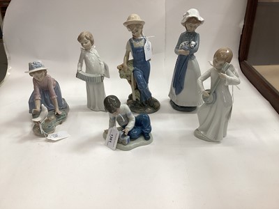 Lot 1361 - Nine Nao porcelain figures including boy with train, girl with bird, two angels playing instruments and three dogs, together with another Spanish figure (10)