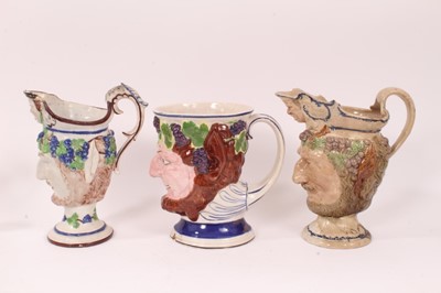 Lot 14 - Three large early 19th century Staffordshire pottery Satyr-mask jugs, 18.5cm to 22cm high