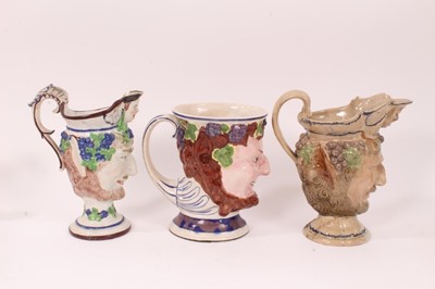 Lot 14 - Three large early 19th century Staffordshire pottery Satyr-mask jugs, 18.5cm to 22cm high