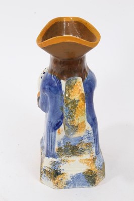 Lot 10 - Prattware Toby jug, circa 1800, seated and holding frothing jug of beer, decorated in typical colours, with sponged base, back and handle