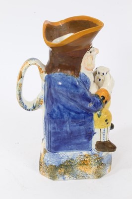 Lot 10 - Prattware Toby jug, circa 1800, seated and holding frothing jug of beer, decorated in typical colours, with sponged base, back and handle
