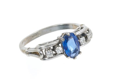 Lot 451 - Sapphire and diamond ring with an oval mixed cut blue sapphire measuring approximately 7.40mm x 5.10mm x 2.98mm, estimated to weigh approximately 0.94cts, flanked by four eight-cut diamonds estimat...