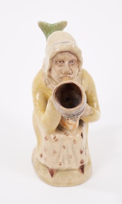 Lot 19 - Prattware figure, circa 1810, in the form of Martha Gunn smoking a large pipe, with a serpent form handle and cat on her lap, decorated in typical Prat colours, 11.5cm high