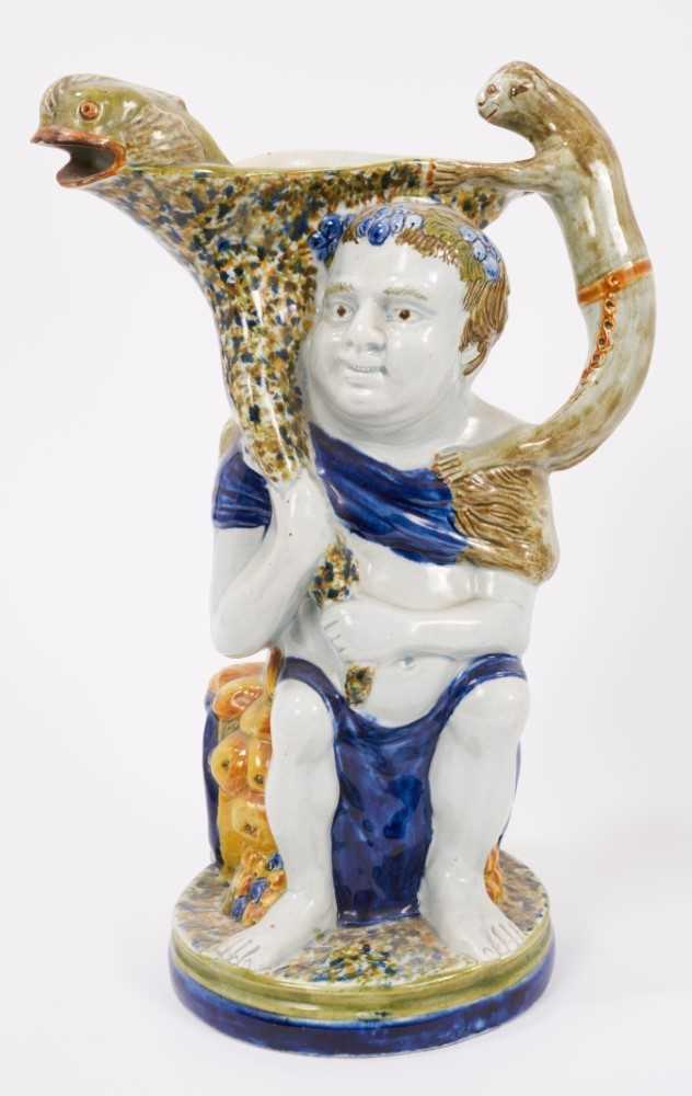 Lot 21 - Prattware 'Bacchus & Pan' jug, circa 1800, Bacchus shown seated on a barrel, with dolphin form spout and monkey handle, Pan to the reverse stood next to an owl, 30cm high
