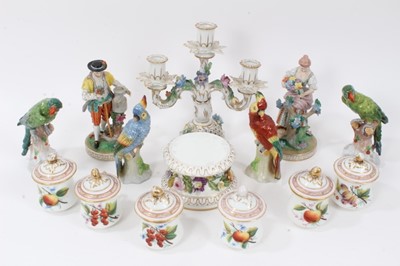 Lot 28 - Group of continental porcelain, including a pair of Dresden figures, four Dresden parrots, a set of six chocolate cups and covers decorated with fruit, a candelabra and a floral-encrusted plinth