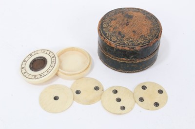 Lot 804 - Georgian ivory counter box of circular form, with engraved screw on cover with metal insert, containing four ivory discs engraved with circles 1-4, in a leather outer case. Box 3cm diameter.