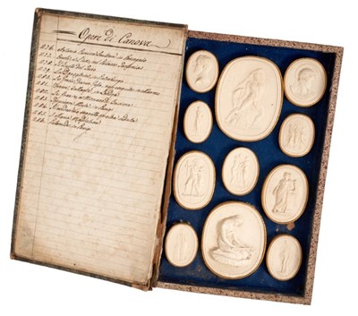 Lot 803 - Early 19th century set of Grand Tour plaster intaglios, depicting works by Canova, in a faux book, with marbled covering and gilt tooled spine, inscribed PAOLETTI, OPERE DI CANOVA, 7, the hinged to...