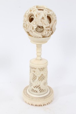 Lot 224 - Chinese export carved ivory puzzle ball, 5.5cm diameter, raised on pierced and carved stand, together with a group of Japanese ivory okimo, with missing elements