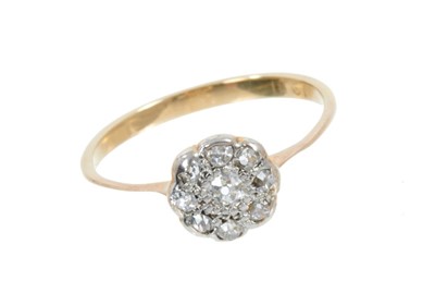 Lot 414 - Early 20th century diamond daisy cluster ring with old cut diamonds in platinum setting on 18ct yellow gold shank, finger size N. Circa 1900-1920.