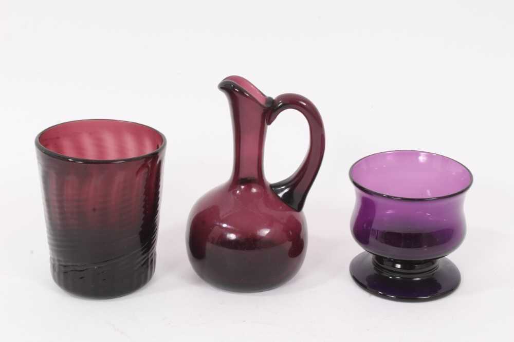 Lot 108 - A 19th century amethyst tinted glass wrythen beaker, a small jug and a small baluster shaped bowl