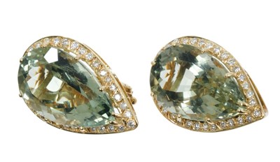 Lot 455 - Pair of diamond and quartz ear clips, each with a large pair cut blue/green quartz surrounded by a border of 32 brilliant cut diamonds in 18ct yellow gold setting. Estimated total diamond weight ap...