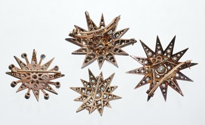 Lot 427 - Four diamond star brooches with old cut and brilliant cut diamonds in silver setting on gold, largest approximately 42mm.