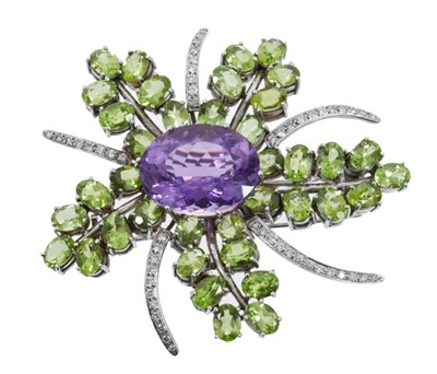 Lot 473 - Diamond, peridot and amethyst brooch in the form of a stylised floral spray with central oval mixed cut amethyst, oval cut peridots and brilliant cut diamonds in 18ct white gold setting, 70mm.