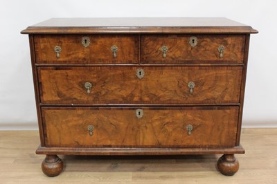 Lot 1476 - Early 18th century and later walnut veneered chest with crossbanded top, two short and two long drawers with brass peardrop handles and brass side handles on bun feet 114 cm wide, 51 cm deep, 84 cm...