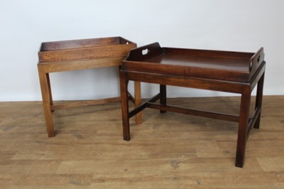 Lot 1445 - Near pair of mahogany butlers trays on stands, each with pierced carrying handles, raised on square section frame, 66cm and 59cm wide respectively. (2)