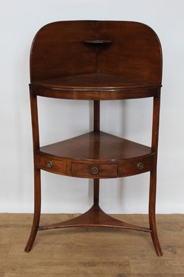 Lot 1446 - George III mahogany corner washstand, with arched gallery and central tier with frieze drawer on splayed supports, 58cm wide