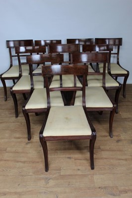 Lot 1460 - Matched set of twelve Regency style mahogany dining chairs, each with bar back and slip in seat on sabre legs, to include pair of scroll arm carvers, basically 19th century and set of four and set...