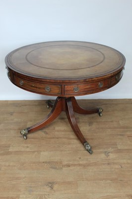 Lot 1463 - Regency mahogany and tooled leather inset drum table, with circular top and four frieze drawers punctuated by dummy drawers, raised on ring turned column and splayed reeded legs terminating in bras...