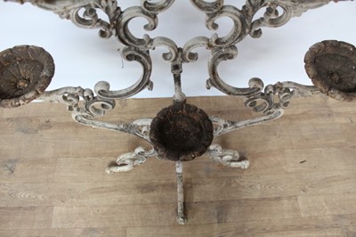 Lot 1474 - Antique cast iron plant stand, with six dished holders (one missing) issuing from scrolled frame on scrolling splayed supports, 92cm wide x 108cm high