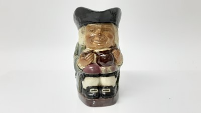 Lot 1313 - Doulton Lambeth stoneware Toby jug, shown holding a jug and mug of frothing beer