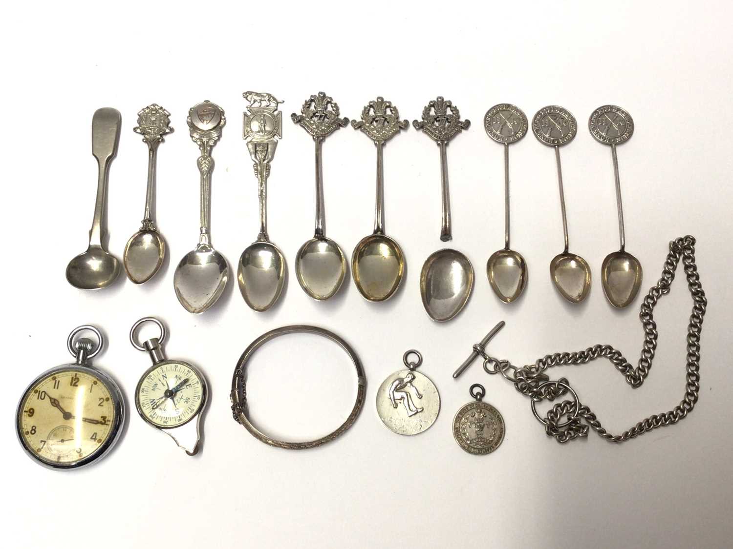 Lot 34 - Collection of silver and plated military related teaspoons, WWII pocket watch, chain, silver fobs etc