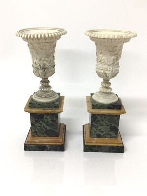 Lot 1 - Fine pair of ivory campana vases, circa early 19th century and probably Italian, carved in relief with Bacchanalian scenes, with satyr mask handles, on square marble pedestal bases, 19.5cm high