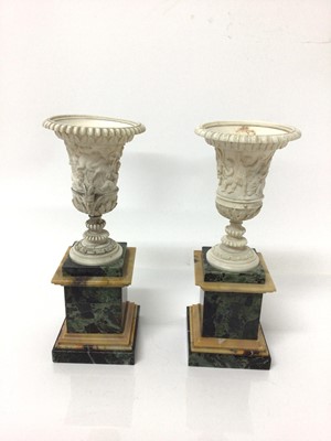Lot 1 - Fine pair of ivory campana vases, circa early 19th century and probably Italian, carved in relief with Bacchanalian scenes, with satyr mask handles, on square marble pedestal bases, 19.5cm high