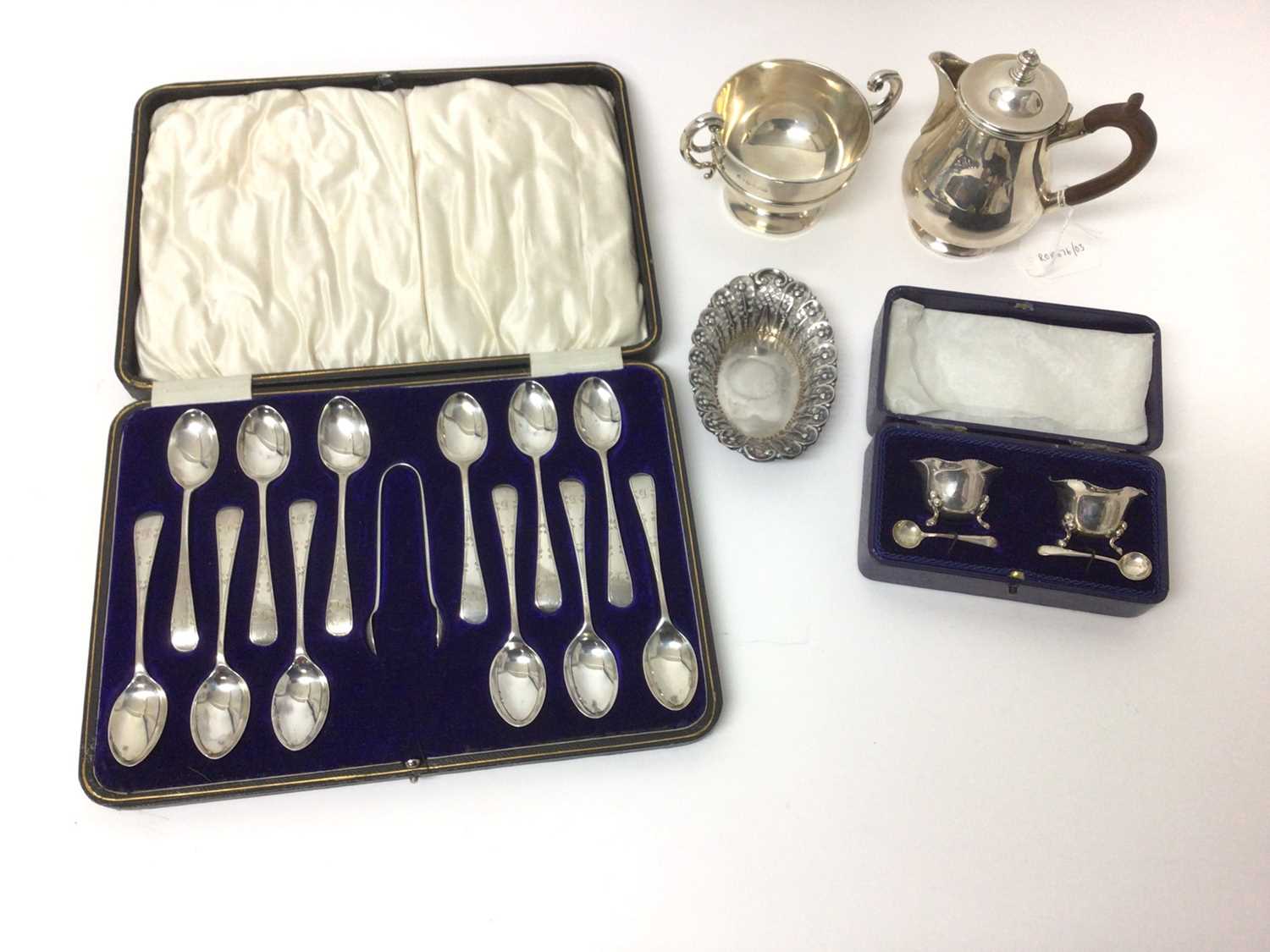 Lot 73 - Silver hot water/hot milk jug, set of twelve silver teaspoons and sugar tongs in fitted case, pair of silver salts with spoons on original fitted box, silver two handled trophy and a silver bon bon...