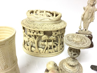 Lot 15 - Group of antique ivory, including a pair of Indian figures of gods, a dice shaker, a relief carved box, an okimono, a Canton puzzle ball stand, a clam netsuke, and two other figures, along with sto...