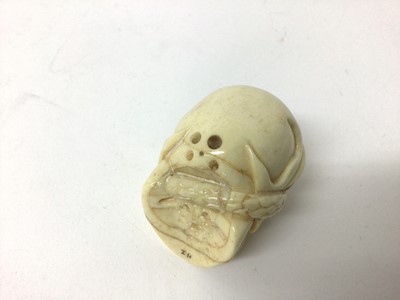 Lot 99 - Japanese ivory netsuke, carved in the form of a skull with a snake writhing through it, signed