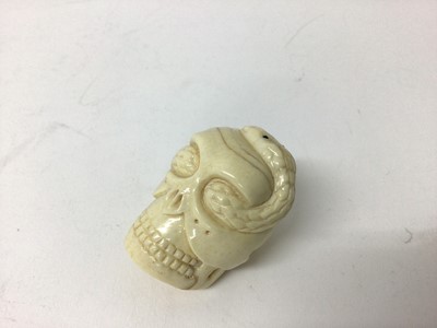 Lot 99 - Japanese ivory netsuke, carved in the form of a skull with a snake writhing through it, signed