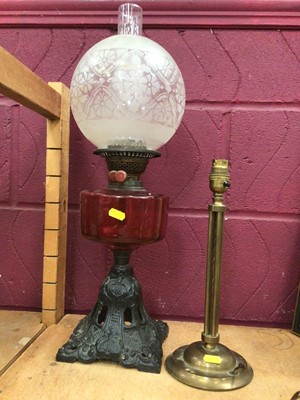 Lot 555 - Brass oil lamp with cranberry reservoir, together with three stylish early 20th century lamps (4)