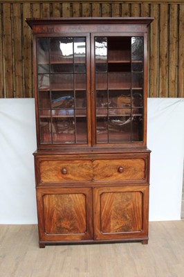 Lot 1282 - George IV mahogany two height secretaire bookcase, the glazed upper section enclosing three adjustable shelves above a fitted secretaire drawer and twin cupboard doors below with single drawer and...