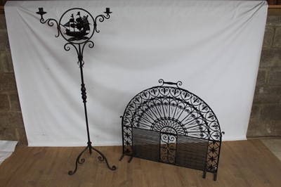 Lot 1012 - Large ornate arched wrought iron fire guard, together with a wrought iron twin branch candle stand (2)