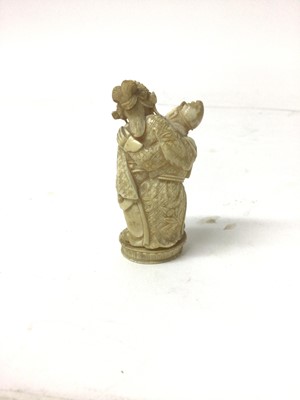 Lot 37 - 19th century carved ivory group, showing a woman seated on a man's lap, 6.5cm high