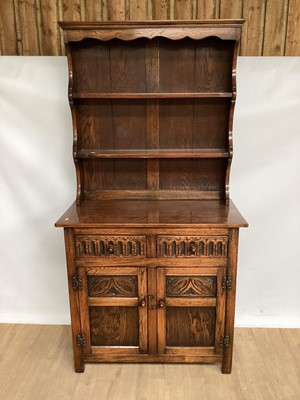 Lot 873 - Oak two height dresser with open shelves above, two drawers and two carved panelled doors below, 91cm wide, 42.5cm wide, 177cm high