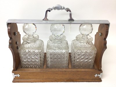 Lot 272 - Edwardian oak three bottle tantalus with silver plated mounts
