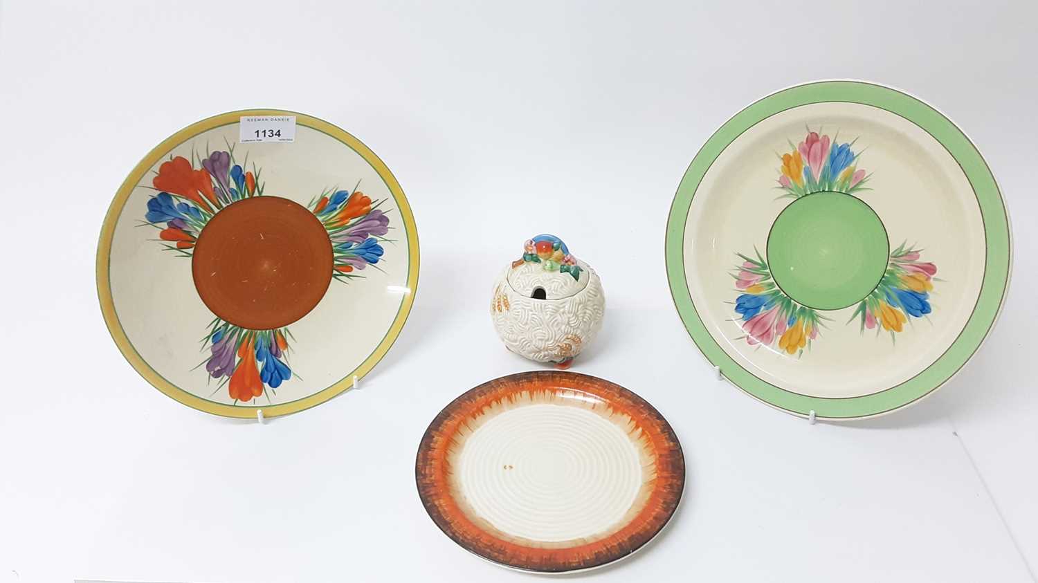 Lot 1134 - Three Clarice Cliff plates, together with a Celtic Harvest preserve pot (4)