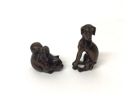 Lot 339 - Two wooden Japanese netsuke of animals - one a dog and the other a cat with a rat seated on him