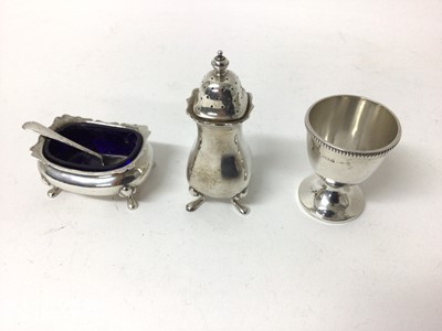 Lot 232 - Silver pepperette, salt and spoon, Birmingham 1927 (Walker & Hall), with scalloped rims and scrollwork feet, together with a silver egg cup, Birmingham, 1939, with beaded rim